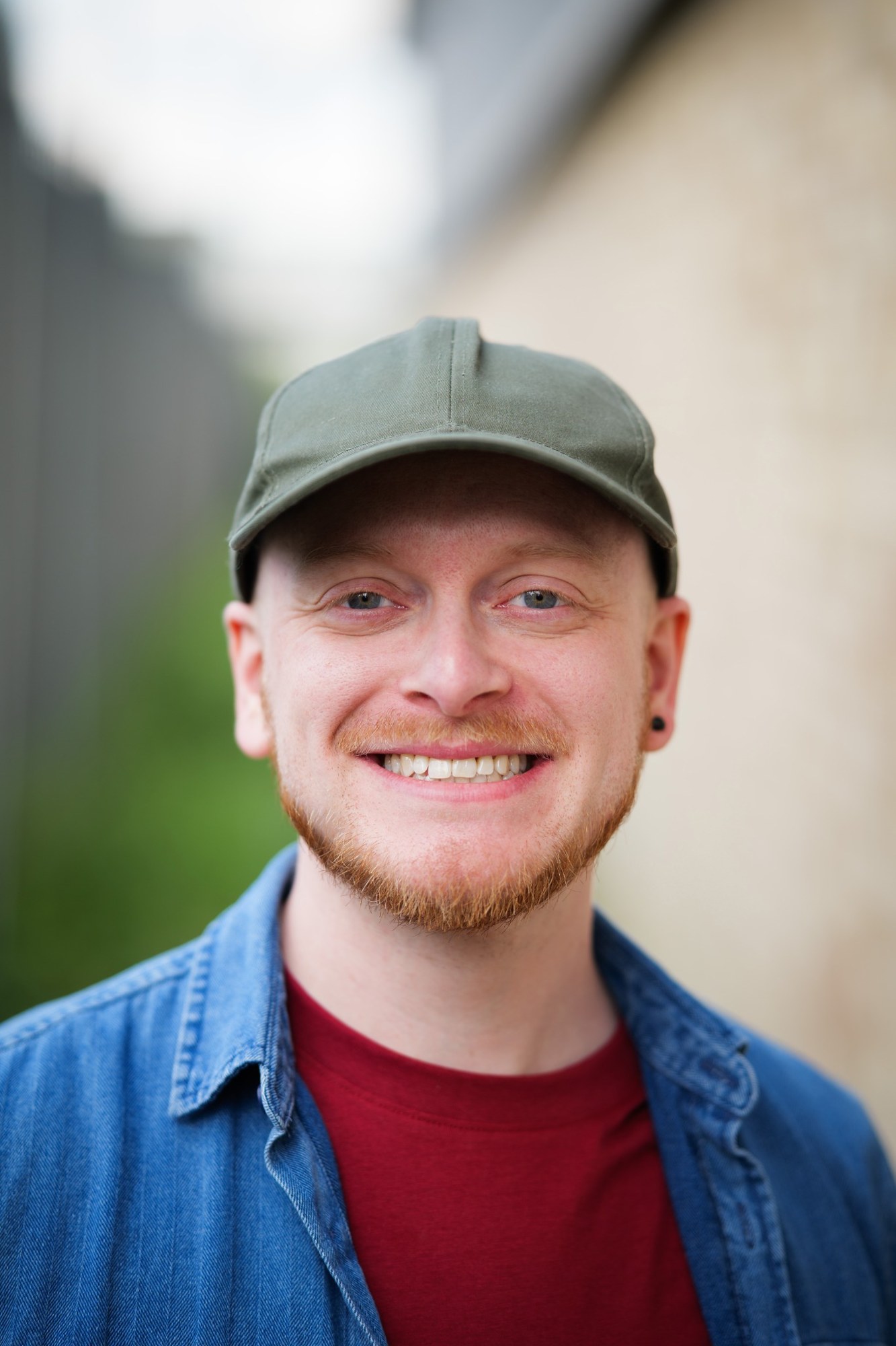 Richard Bland smiling outdoors, wearing a green cap